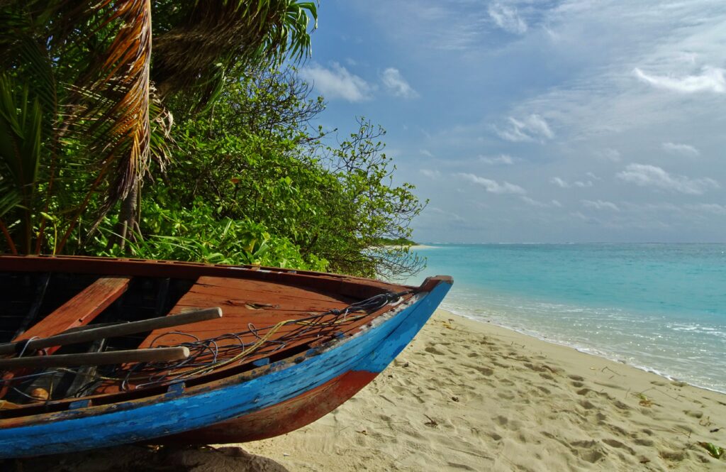 Een bootje ligt afgelegen op het strand van Feridhoo waar we backpacken in de Malediven.